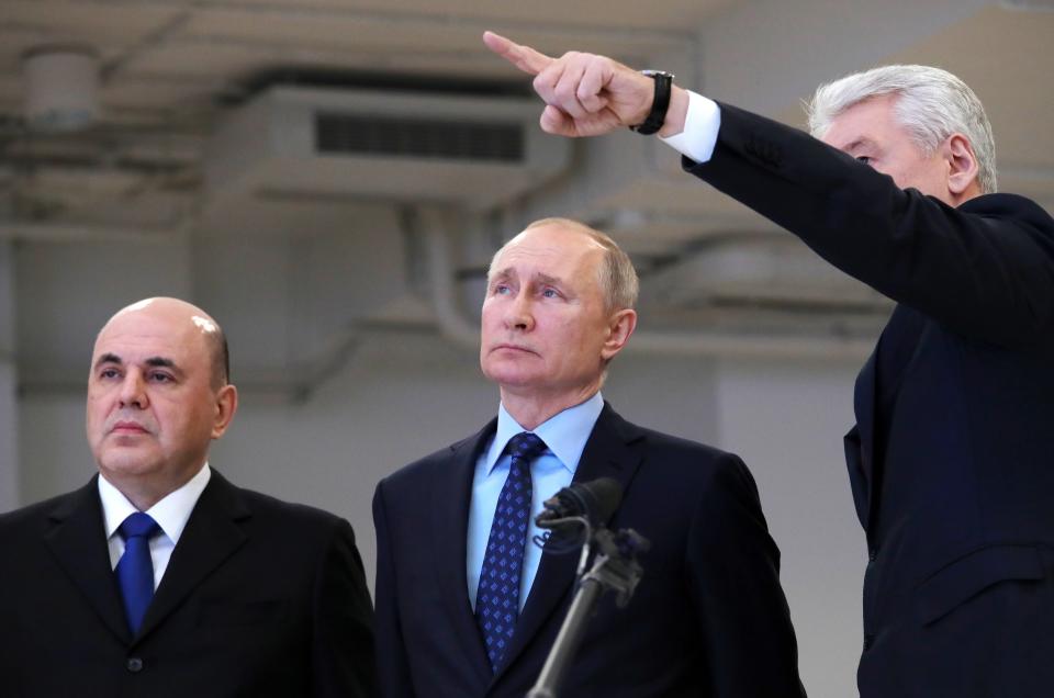 Moscow Mayor Sergei Sobyanin, right, points as he speaks to Russian President Vladimir Putin, center, and Prime Minister Mikhail Mishustin, left, during their visit a call center of the emergency response center on control and monitoring of the coronavirus disease, in Moscow, Russia, Tuesday, March 17, 2020. The Russian government says that it has decided to bar entry to all foreigners starting Wednesday. For most people, the new coronavirus causes only mild or moderate symptoms, such as fever and cough. For some, especially older adults and people with existing health problems, it can cause more severe illness, including pneumonia. (Alexander Astafyev, Sputnik, Kremlin Pool Photo via AP)