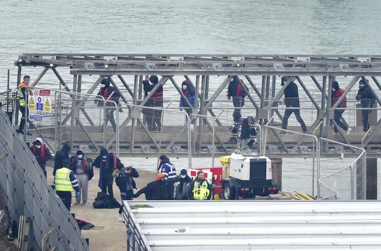 Un grupo de personas que se cree son migrantes desembarcan en Dovert, Kent, desde un barco de la Fuerza Fronteriza tras un incidente con un barco pequeño en el Canal de la Mancha, en Inglaterra, el lunes 6 de marzo de 2023. (Gareth Fuller/PA via AP)