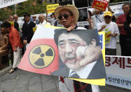 A South Korean protester holds an image of Japanese Prime Minister Shinzo Abe during a rally denouncing the Japanese government's decision on their exports to South Korea in front of the Japanese Embassy in Seoul, South Korea, Tuesday, July 23, 2019. Colonial-era Korean laborers have formally registered their request with a South Korean court to get its approval for the sale of local assets of their former Japanese employer. (AP Photo/Ahn Young-joon)