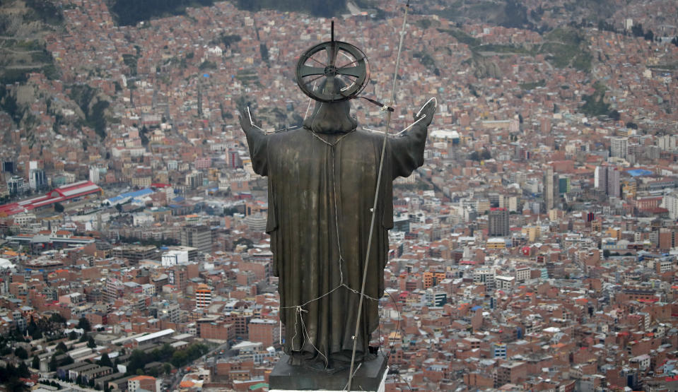 In this picture taken Tuesday, Jan. 7, 2020, a Christ statue overlooks El Alto, a city adjoining the capital city La Paz, Bolivia. Ancestral indigenous practices became more visible during the presidency of Evo Morales, who recognized the Andean earth deity Pachamama. While Bolivians are divided on former President Morales' legacy, the interim President Jeanine Añez wants to make the Bible front and center in public life. (AP Photo/Natacha Pisarenko)