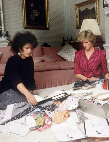 <p>Tim Graham/Getty Images</p> Elizabeth Emanuel (left) and Princess Diana (right) coordinating outfits for a royal tour in 1986.