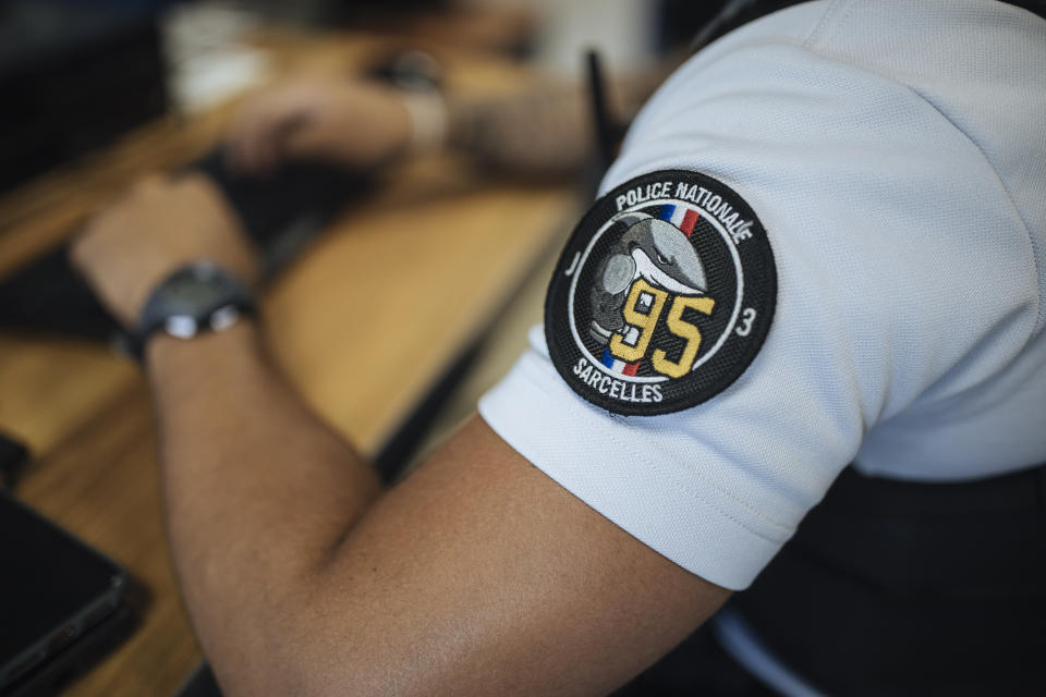 A police officer works in the police station in the Paris suburb of Sarcelles, Tuesday, June, 15, 2021. In Sarcelles, police say they work hard not to stir up tensions and try to reassure people by regularly patrolling neighborhoods that are troubled by drug-dealing and other crime. (AP Photo/Lewis Joly)