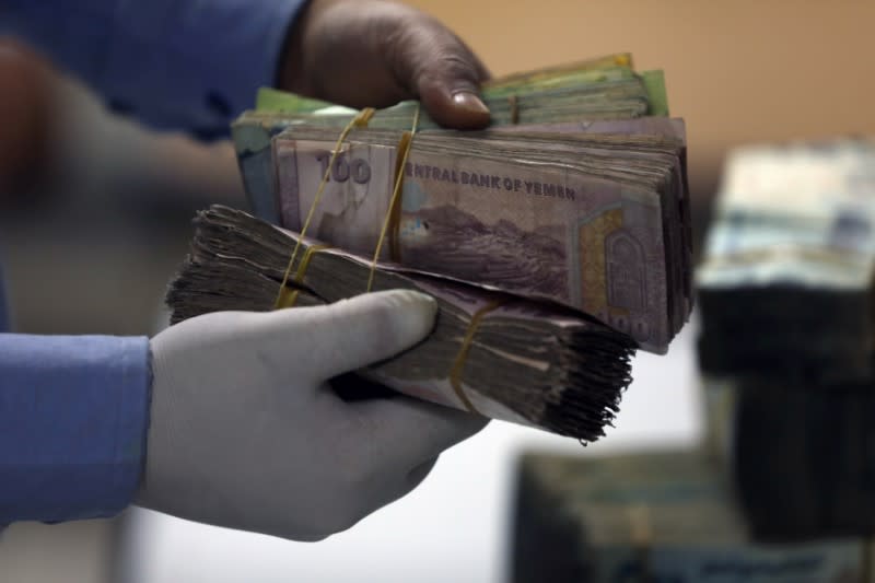 Employee checks a bundle of Yemeni Riyal at the Central Bank of Yemen in Sanaa