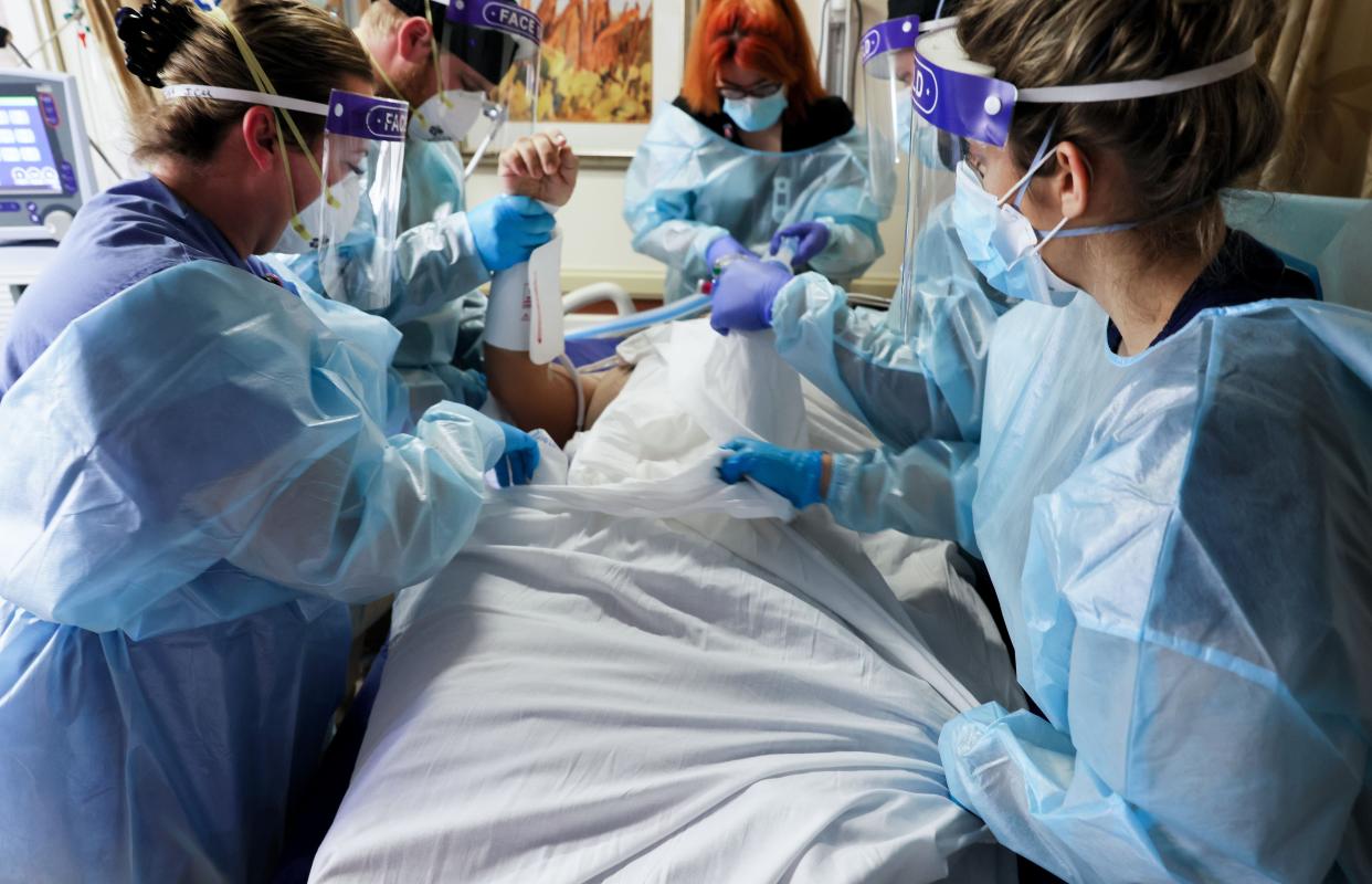 Clinicians re-position a COVID-19 patient into the supine position at Providence St. Mary Medical Center amid a surge in COVID-19 patients at the hospital and across Southern California on January 6, 2021 in Apple Valley, California.