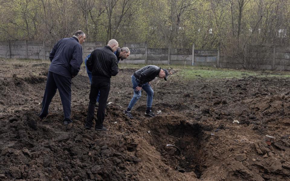 People look at the crater made by a Kalibr missile, amid Russia's invasion, in Kramatorsk, Donetsk region, Ukraine, April 18, 2022. REUTERS/Marko Djurica - REUTERS/Marko Djurica