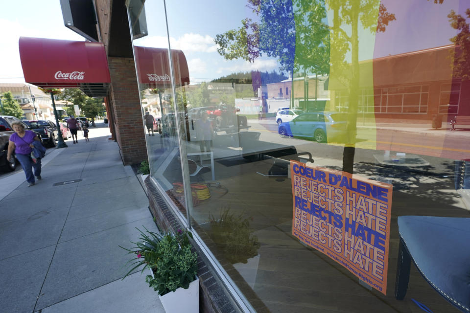 FILE - A sign that reads "Coeur d'Alene Rejects Hate" is shown under a pride flag in the window of the Emerge CDA art gallery, July 18, 2022, in downtown Coeur d'Alene, Idaho. A northern Idaho jury on Thursday, July 20, 2023, found five members of the white nationalist hate group Patriot Front guilty of misdemeanor charges of conspiracy to riot at a Pride event. (AP Photo/Ted S. Warren)