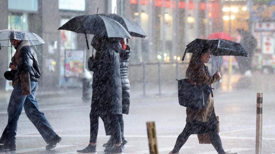 PHOTO: Pedestrians carry umbrellas as they walks through heavy rain in Times Square in New York City, December 18, 2023 (John Angelillo/UPI/Shutterstock)