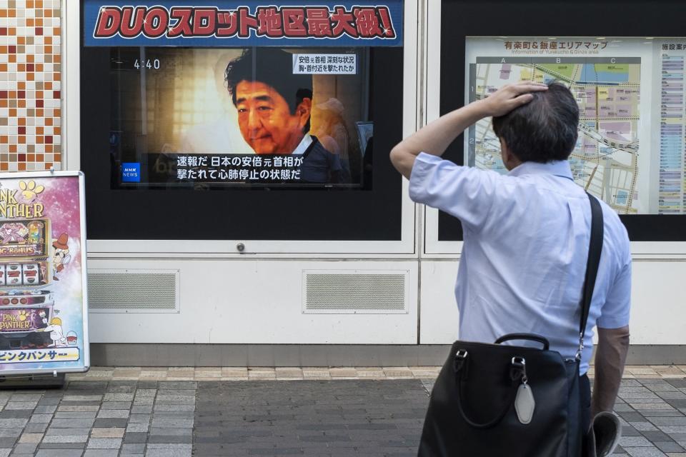 TOPSHOT - A man looks at a television broadcast showing news about the attack on former Japanese prime minister Shinzo Abe earlier in the day, along a street of Tokyo on July 8, 2022. - Shinzo Abe was shot at a campaign event in the city of Nara on July 8, a government spokesman said, as local media reported the nation's longest-serving premier was showing no vital signs. (Photo by Charly TRIBALLEAU / AFP) (Photo by CHARLY TRIBALLEAU/AFP via Getty Images)