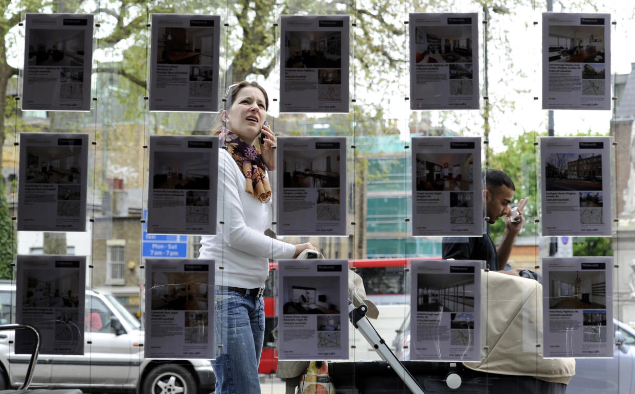 A woman stops to look in the window of an estate agent in Islington, north London. Photo: Paul Hackett/Reuters