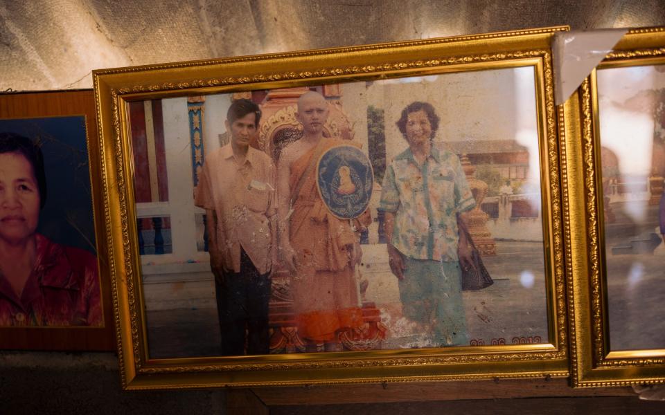 A picture of Boonsri Pakdee, 69 and her husband Pae Pakdee (L) attending their grandsonâ€™s Buddhist monk ordination ceremony hangs in her home in Ban Nong Prue Kan Yang