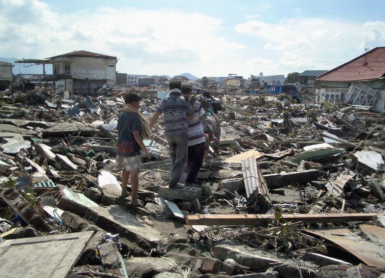 A day after the tsunami, residents in Banda Aceh carry the body of a dead relative across the rubble of their village. The vast majority, some 170,000 of the 220,000, deaths resulting from the earthquake and tsunami were in Indonesia