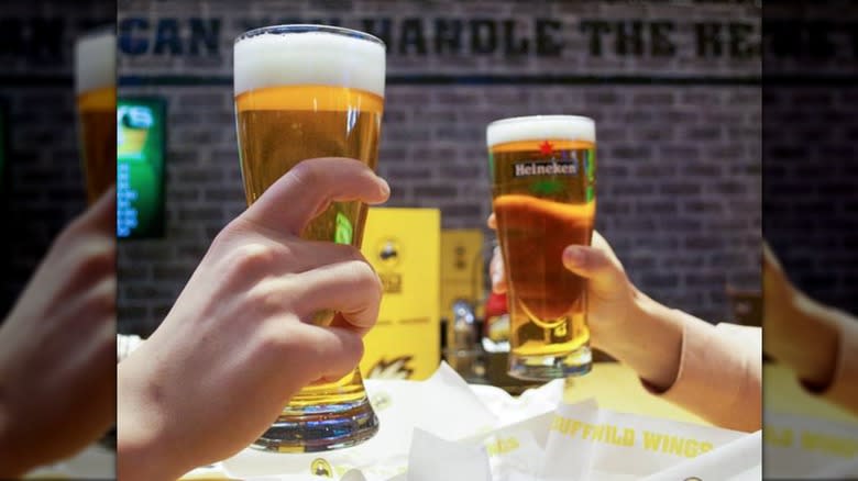 people holding beer glasses