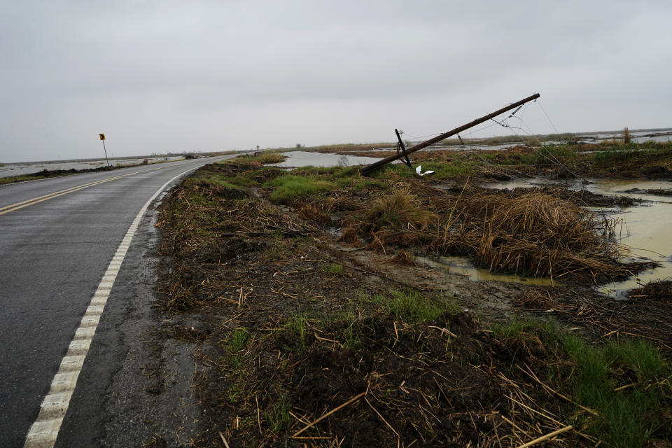 Downed power lines from Hurricane Laura line a desolate stretch of marsh on Hwy 27, leading to the town of Cameron, La., in advance of Hurricane Delta, in Cameron Parish, La., Thursday, Oct. 8, 2020. (AP Photo/Gerald Herbert)