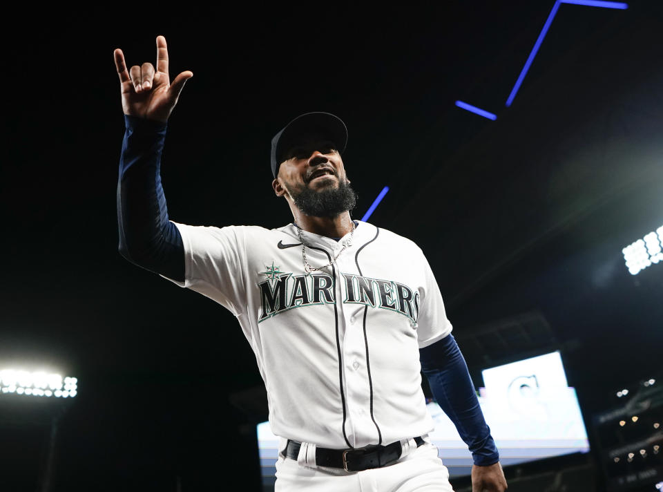 Seattle Mariners right fielder Teoscar Hernandez, who hit two home runs in the game, gestures to fans after an interview following the team's baseball game against the Los Angeles Angels on Tuesday, April 4, 2023, in Seattle. The Mariners won 11-2. (AP Photo/Lindsey Wasson)