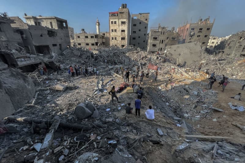 Palestinians inspect the destroyed buildings following an Israeli airstrike on Jabalia refugee camp. sraeli troops are engaged in fierce fighting with armed Palestinians in the north of the Gaza Strip, Israeli media reported on Sunday. Fadi Wael Alwhidi/dpa