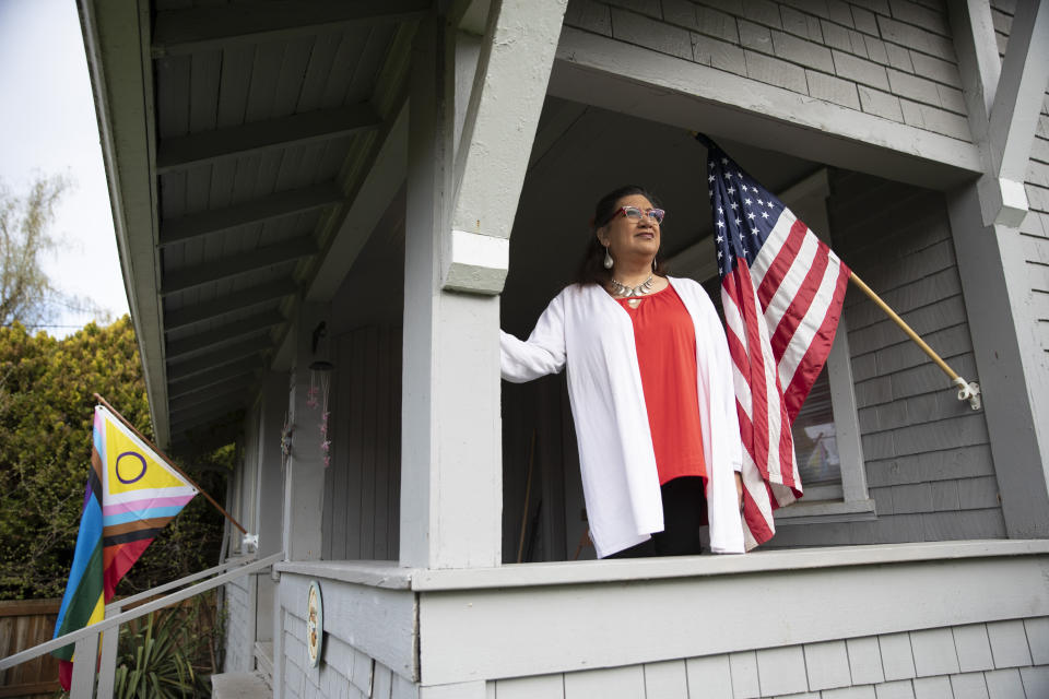 Christina Wood stands on the porch of her home in Salem, Ore., Friday, April 21, 2023. For most of her life in New Mexico, Wood felt like she had to hide her identity as a transgender woman. So six years ago she moved to Oregon, where she could access the gender-affirming health care she needed to live as her authentic self. Oregon lawmakers are expected to pass a bill that would further expand insurance coverage for gender-affirming care to include things like facial hair removal and Adam's apple reduction surgery, procedures seen as critical to the mental health of transitioning women. (AP Photo/Amanda Loman)