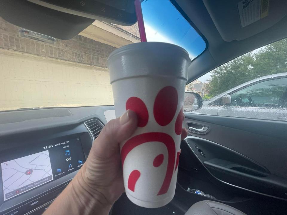 The writer holds a cup of Chick-fil-A sweet tea with logo on it