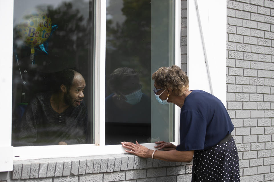 Southern Pines nursing home resident Wayne Swint gets a birthday visit from his mother, Clemittee Swint, in Warner Robins, Ga., on Friday, June 26, 2020. Face to face visits are not allowed but staff members help arrange window visits. (AP Photo/John Bazemore)