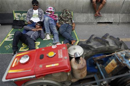 Rice farmers rest by their tractors on a main highway where they spent a night in Ayutthaya province February 21, 2014. REUTERS/Damir Sagolj