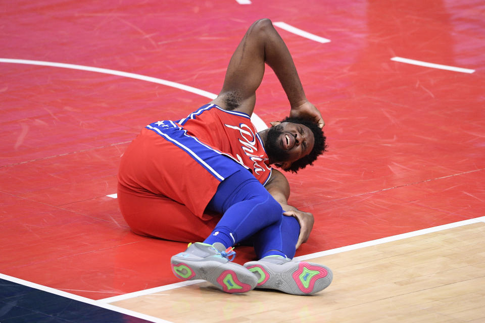 Philadelphia 76ers center Joel Embiid (21) reacts after an injury during the second half of the team's NBA basketball game against the Washington Wizards, Friday, March 12, 2021, in Washington. (AP Photo/Nick Wass)