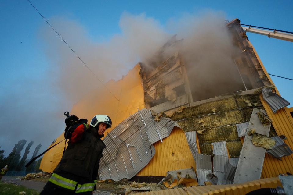 A firefighter works at a site of a tobacco factory damaged during Russian suicide drone strike, amid Russia’s attack on Ukraine, in Kyiv, Ukraine 28 May 2023 (Reuters)