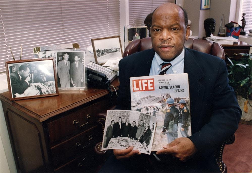Congressman John Lewis is seen in his Atlanta office with two of his favorite items from his collection of memorabilia from his younger days as a civil rights activist in the 1960s. He is holding a Life Magazine cover picturing the famous Selma march in 1965. (He is in this photo at front of the line of marchers.) He is also holding a photo of the ‘Big Six’ civil rights leaders of the time to plan for the famous March on Washington. The men in the photo are L to R: John Lewis, Whitney Young, A. Phillip Randolph, Martin Luther King, James Farmer, and Roy Wilkins. In background photos (picture at left) of Dr. Martin Luther King with Fred Shuttlesworth and Ralph Abernathy and Lewis with Robert Kennedy (picture at right).” (Atlanta Journal-Constitution via AP)