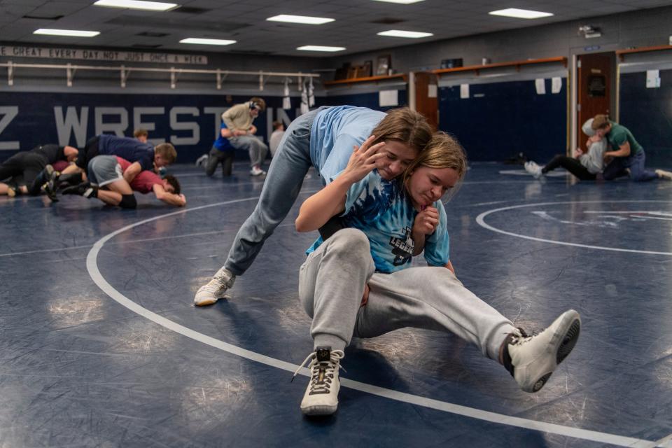 Lili Greenfield, left, and Justice Lambert wrestle during practice at Reitz High School Thursday, Jan. 4, 2024.