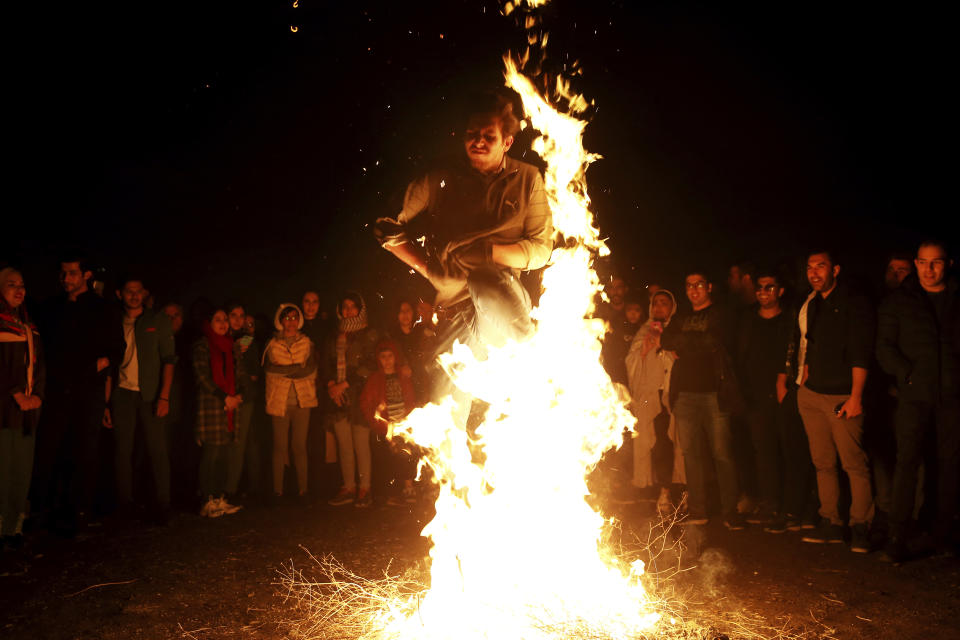 An Iranian man jumps over a bonfire during a celebration, known as "Chaharshanbe Souri," or Wednesday Feast, marking the eve of the last Wednesday of the solar Persian year, Tuesday, March 19, 2019 in Tehran, Iran. Iran's many woes briefly went up in smoke on Tuesday as Iranians observed a nearly 4,000-year-old Persian tradition known as the Festival of Fire. (AP Photo/Ebrahim Noroozi)