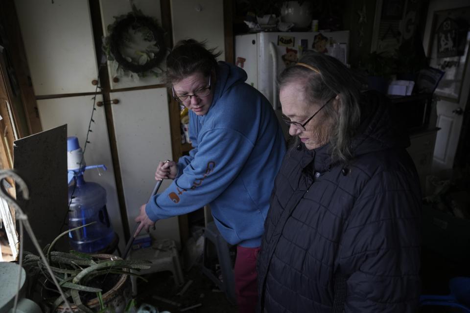 Billie Cole helps her mother-in-law Patricia Gaddis clean up storm damage at her mobile home Friday, March 15, 2024, in Lakeview, Ohio. (AP Photo/Joshua A. Bickel)