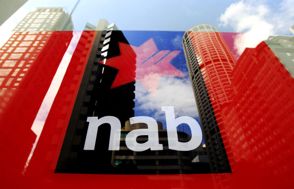 Buildings are reflected in a window at a National Australia Bank branch in Sydney, Australia, Tuesday, Feb. 8, 2011. National Australia Bank, one of the country's largest lenders, reported an 18 percent rise in first quarter cash profit, citing a boost in business lending and fewer bad debts. (AP Photo/Rick Rycroft)