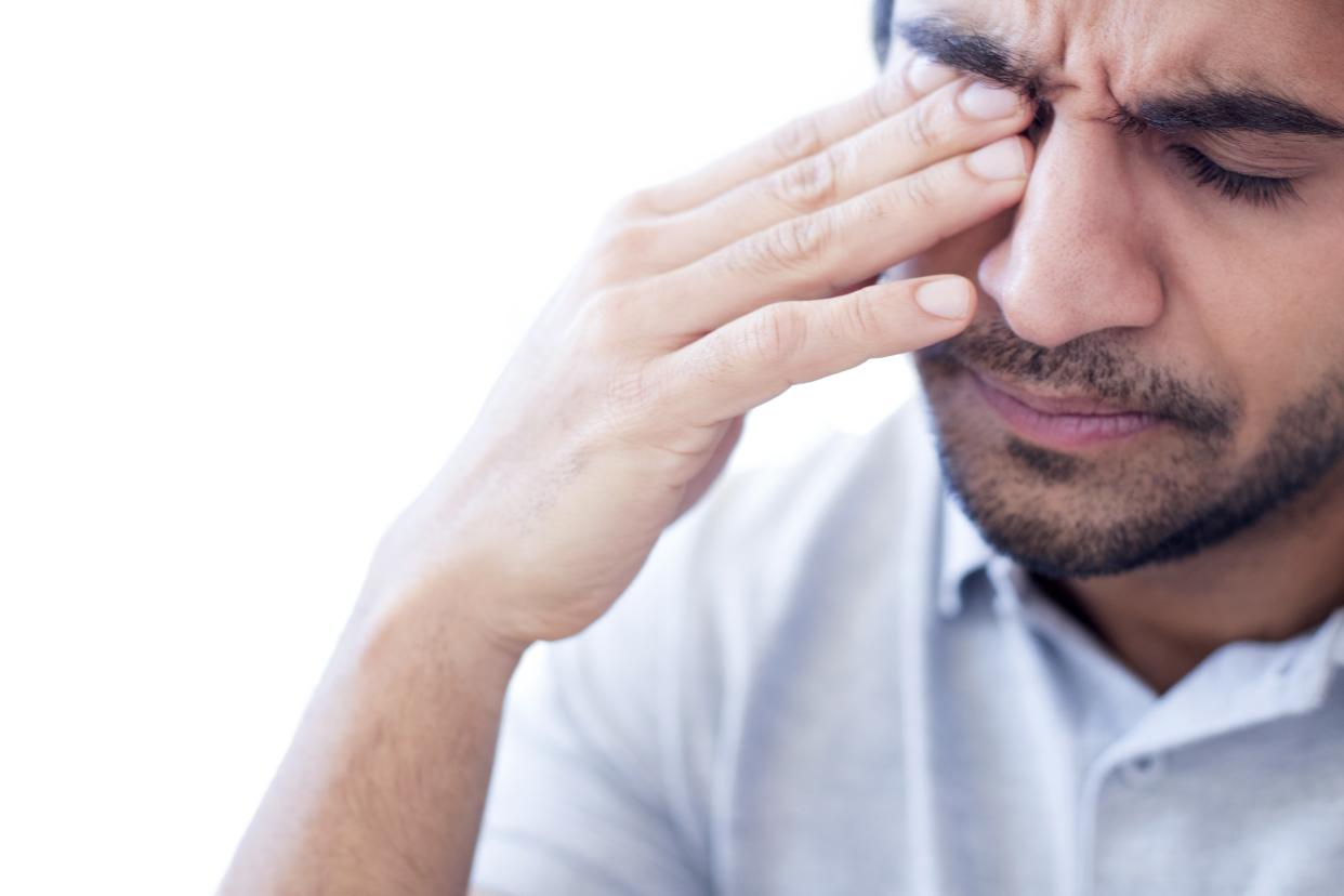 Man rubbing his right eye in pain. (Getty Images)