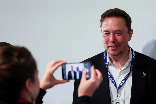 A mobile phone user takes a photo of Elon Musk