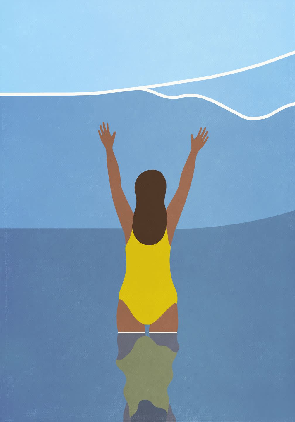 happy woman in bathing suit wading in blue ocean