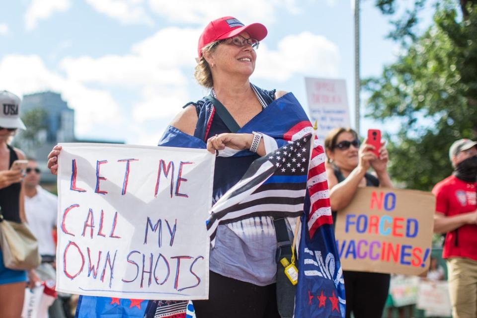 Anti-vaccine activists hold signs in front of the Massachusetts State House (Getty)