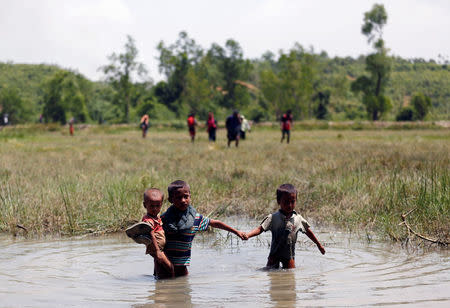 Rohingya children make their way through water as they try to come to the Bangladesh side from No Man’s Land after a gunshot being heard on the Myanmar side, in Cox’s Bazar, Bangladesh August 28, 2017. REUTERS/Mohammad Ponir Hossain