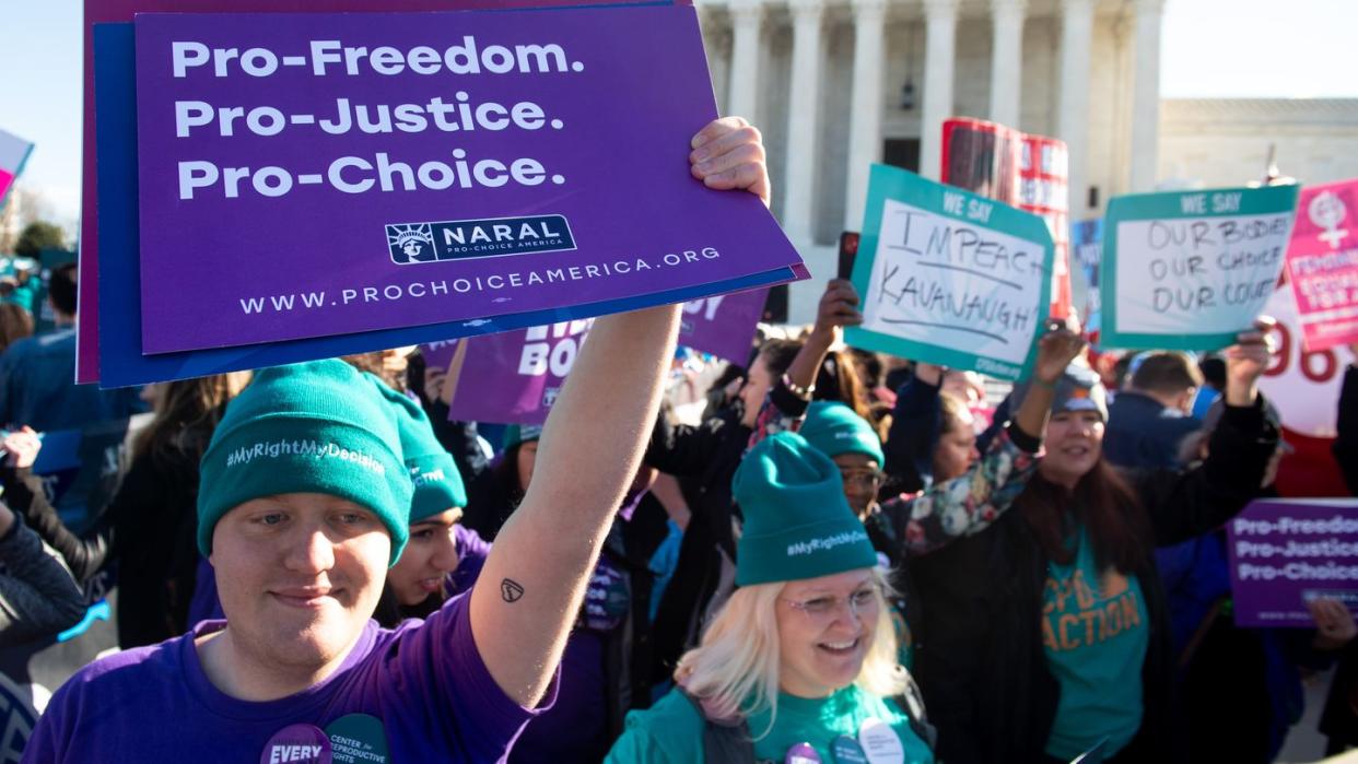 a person holding a sign that says pro freedom pro justice pro choice naral outside the supreme court