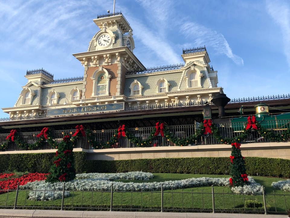 shot of the entrance to magic kingdom theme park disney world decorated for christmas