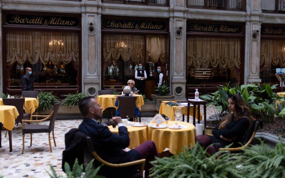 Patrons return to a reopened restaurant in Turin - Getty