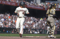 San Francisco Giants' LaMonte Wade Jr., left, scores past San Diego Padres catcher Luis Campusano during the sixth inning of a baseball game in San Francisco, Friday, April 5, 2024. (AP Photo/Eric Risberg)