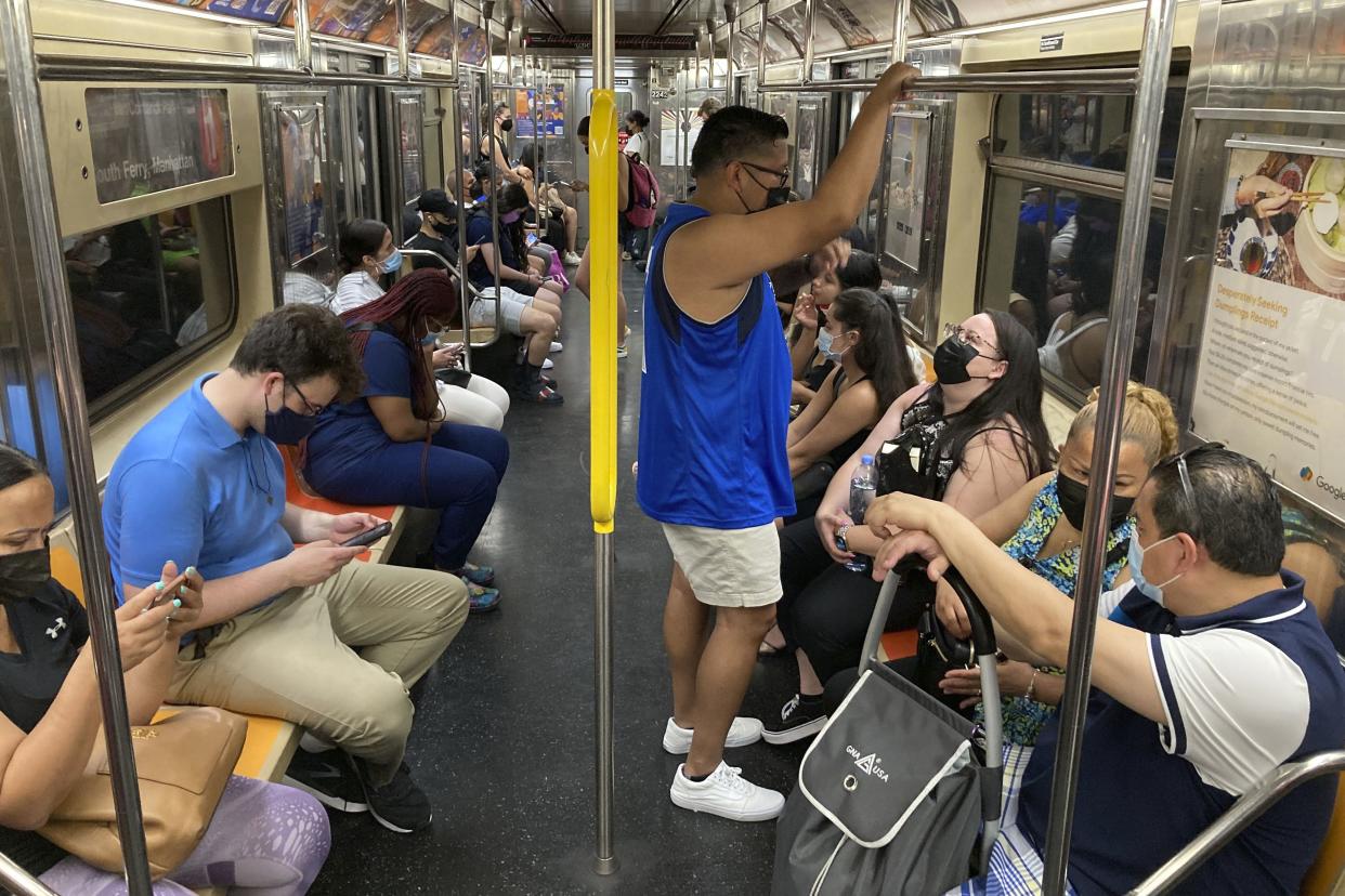 Commuters wear face masks while riding the subway.