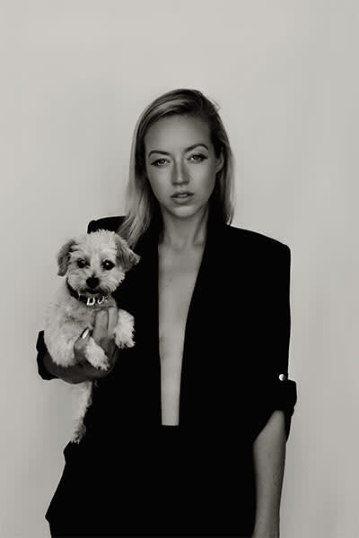 Kelsey Parker holds her dog while wearing revealing blazer