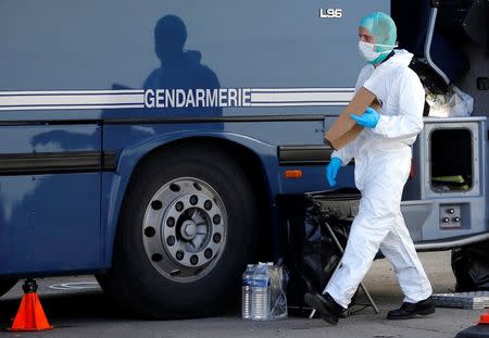 A French investigator walks past a Gendarmerie mobile forensic van in Seynes-les-Alpes near the crash site of an Airbus A320, in French Alps March 27, 2015. REUTERS/Eric Gaillard