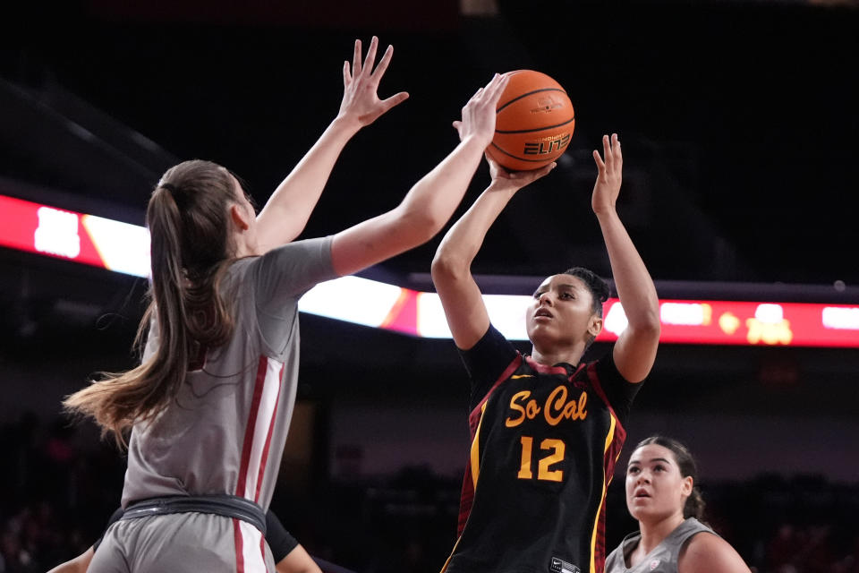 Southern California guard JuJu Watkins, center, shoots as Washington State center Alex Covill, left, defends during the second half of an NCAA college basketball game Friday, Jan. 26, 2024, in Los Angeles. (AP Photo/Mark J. Terrill)