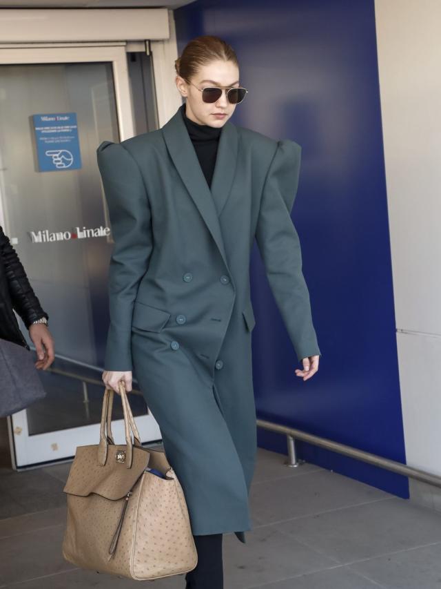 Gigi Hadid wearing Black Coat, Purple Cropped Top, Dark Brown Leggings,  Charcoal Low Top Sneakers