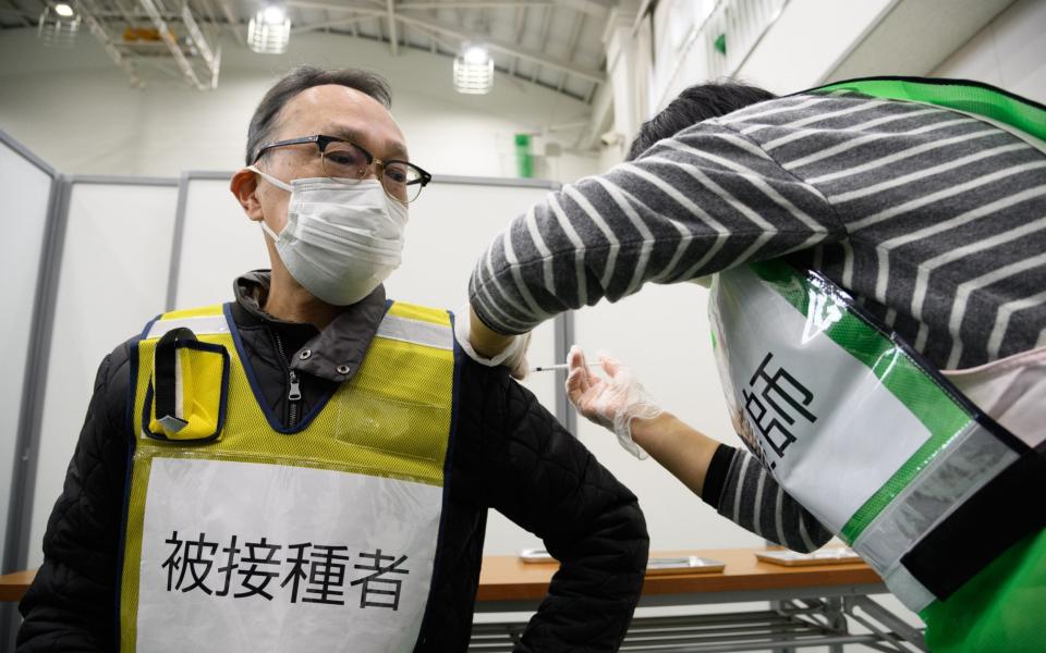 A healthcare worker holds an empty syringe during a vaccination simulation at a gymnasium of Kawasaki City - Bloomberg