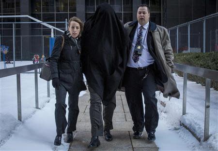 A hooded suspect is escorted by FBI agents from their Manhattan offices in New York February 11, 2014. REUTERS/Brendan McDermid