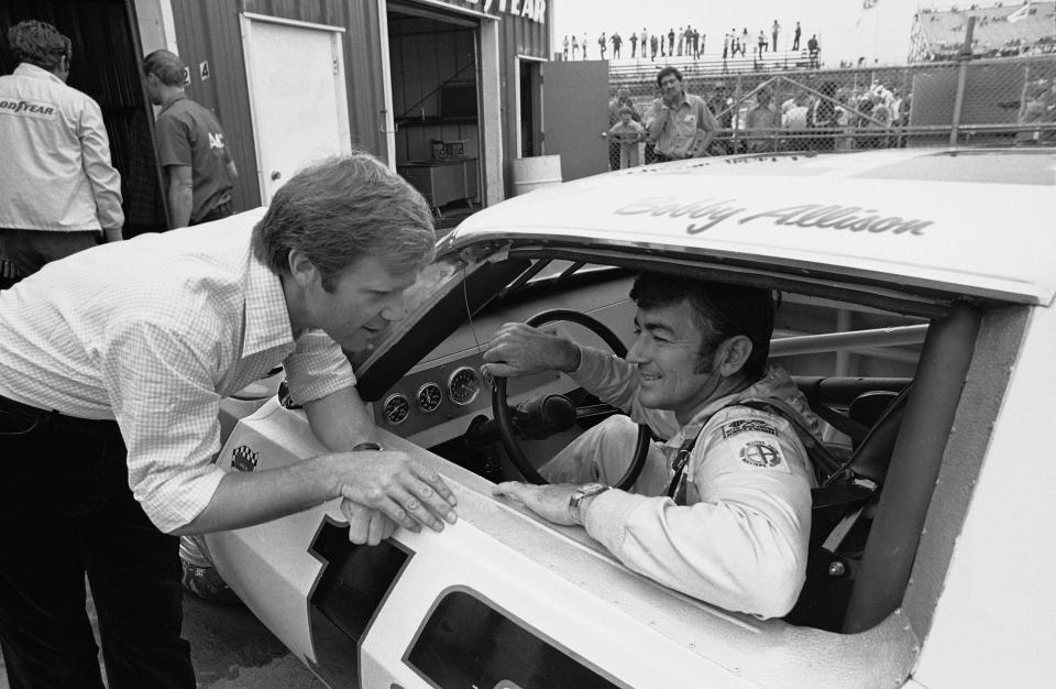 Bobby Allison sits in his racing car talking with Mark Donohue, manager of the Penske Racing Team, giving instructions to Allison during the running of time trials for the Purolator 500 race at Pocono International Raceway, Aug. 3, 1974.