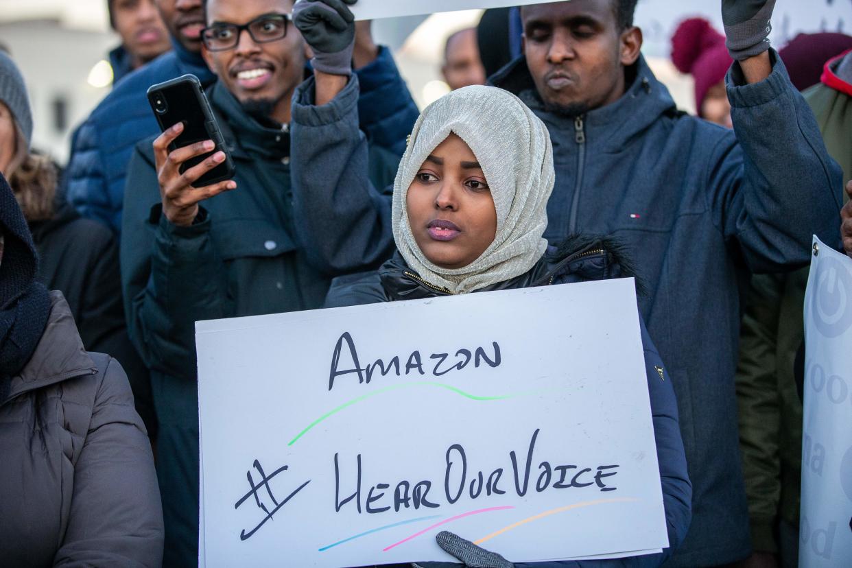 Demonstrators shout slogans and hold placards during a protest at the Amazon fulfillment center in Shakopee, Minnesota, on December 14, 2018. - A group of Amazon workers in Minnesota who are Somali refugees resettled in the Midwestern US state demanded better working conditions during a protest outside one of the retailer's warehouses. Dozens braved frigid temperatures to demonstrate outside of the Amazon warehouse in the Minneapolis suburb of Shakopee -- home to a sizable Somali immigrant population from which Amazon has heavily recruited. (Photo by Kerem Yucel / AFP)        (Photo credit should read KEREM YUCEL/AFP/Getty Images)