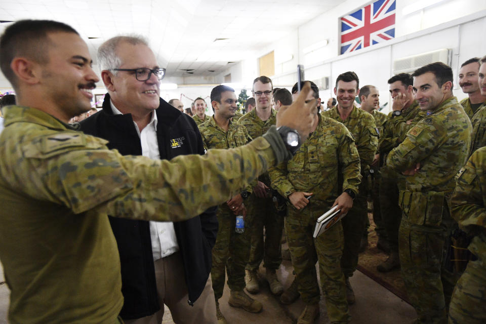 Australian Prime Minister Scott Morrison, second from left, is seen during a visit to Task Group Taji at Taji Military Complex in Iraq, Wednesday, Dec. 19, 2018. Prime Minister Morrison has made a pre-Christmas visit to hundreds of troops in Iraq, telling them he wanted to say thank you from "one Australian to another." (David Mariuz/AAP Image via AP)