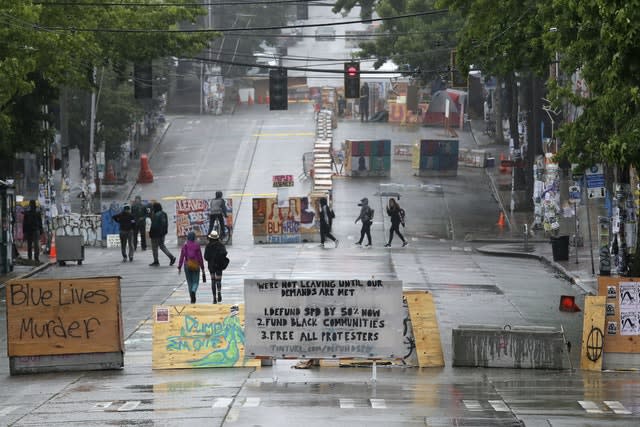 People walk past barricades in Seattle (Elaine Thompson/AP)